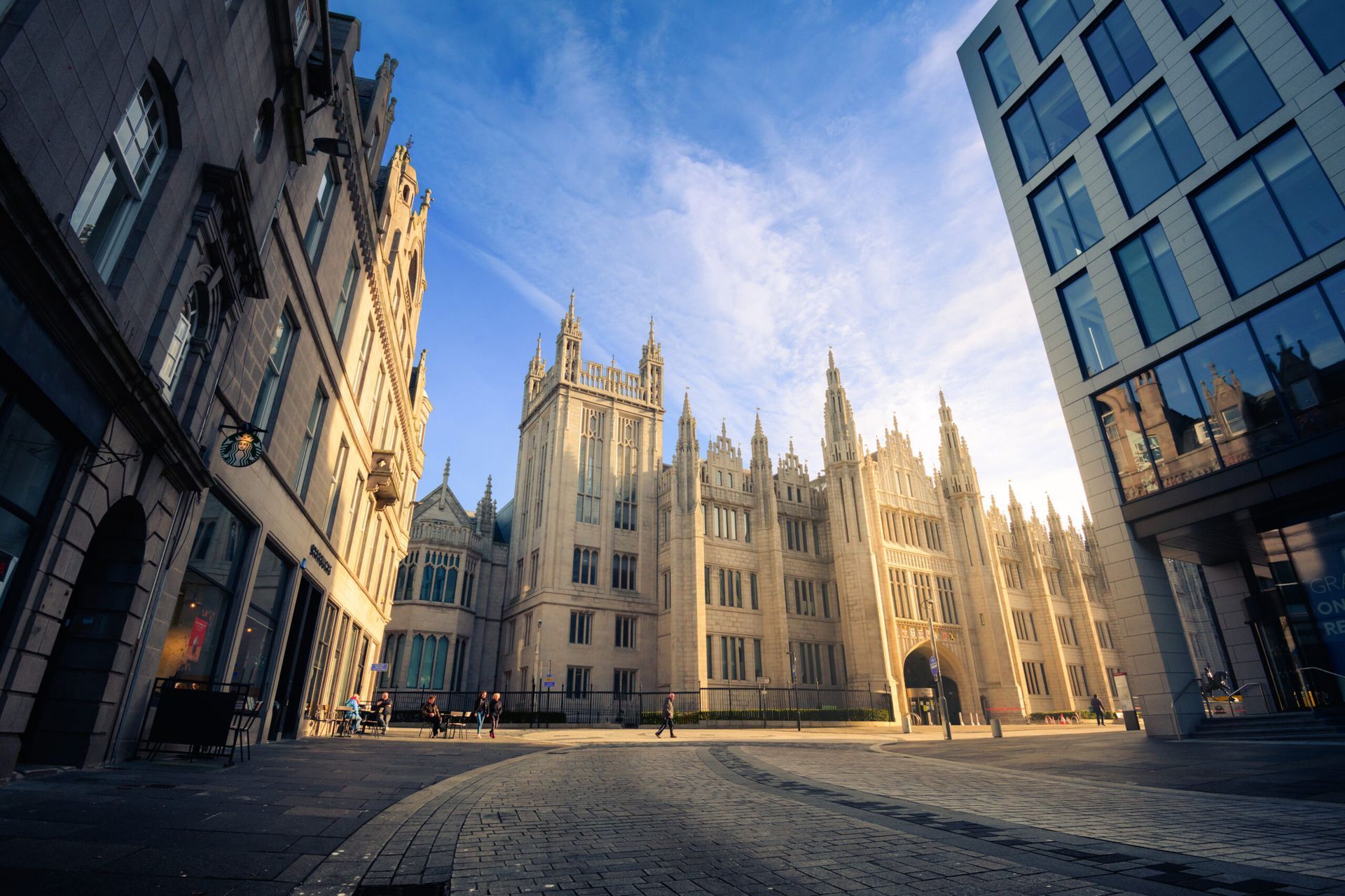 Stone buildings and paved street with bright sunlight and blue sky.