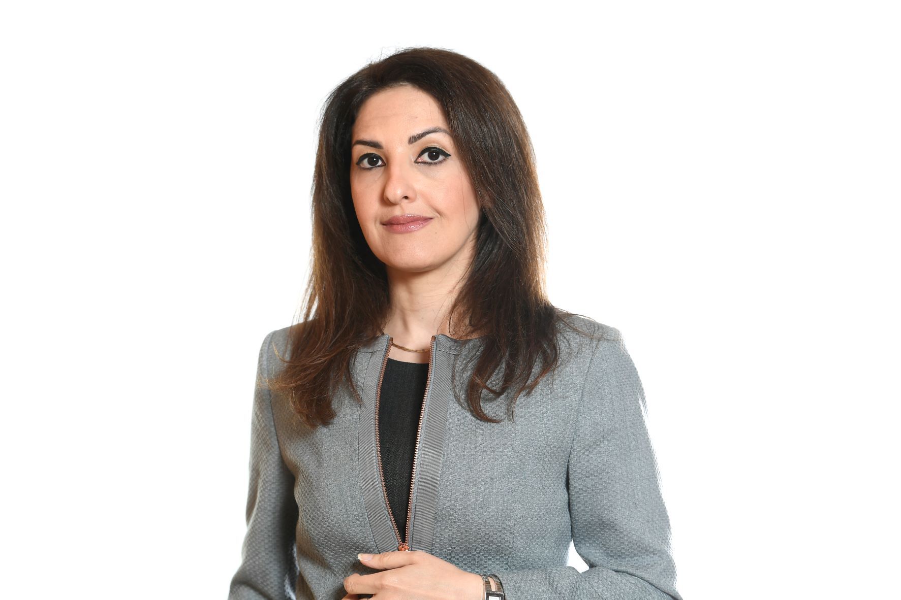 Woman in gray blazer, facing forward, against a white background.