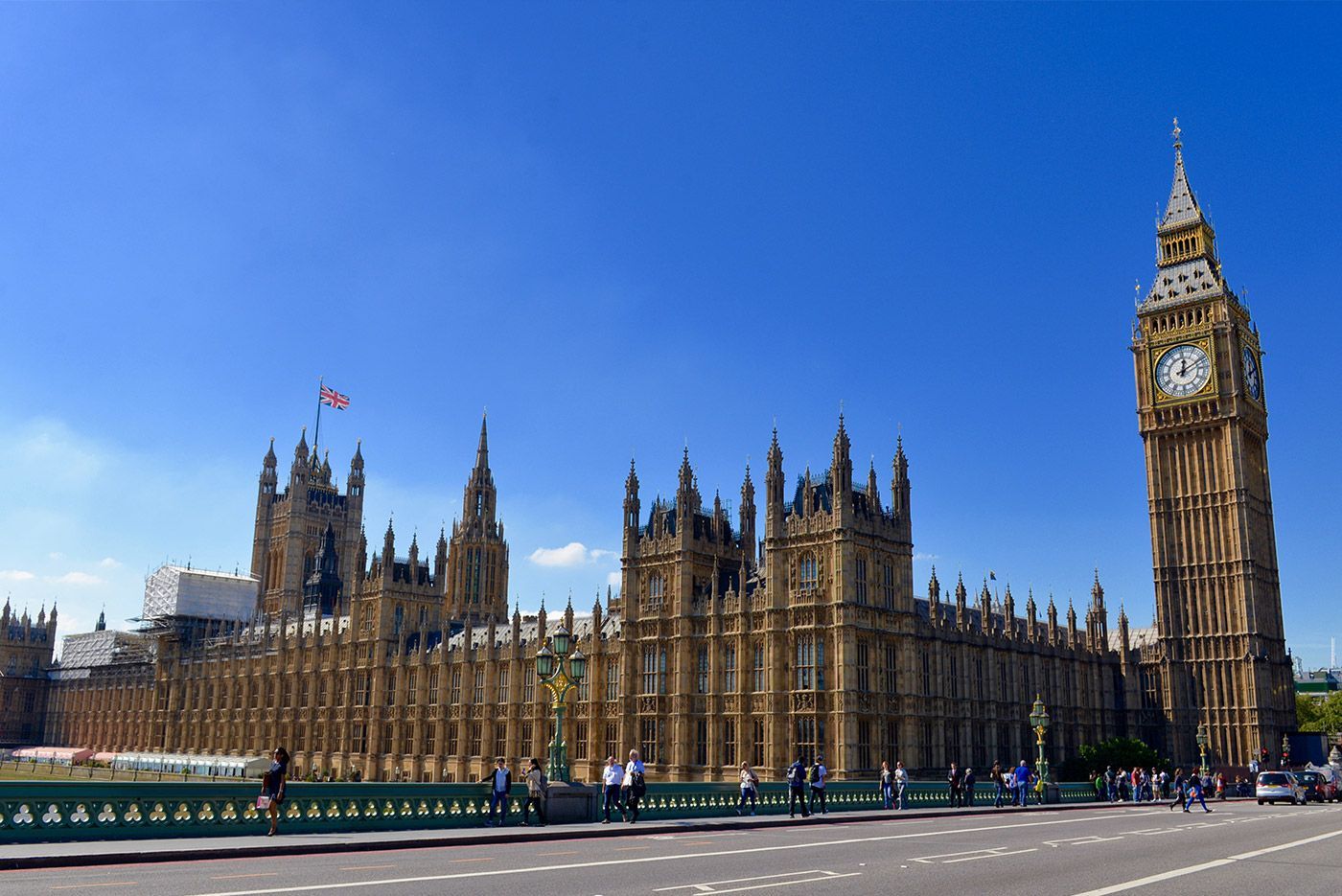 Houses of Parliament and Big Ben clock tower in London, under a blue sky.