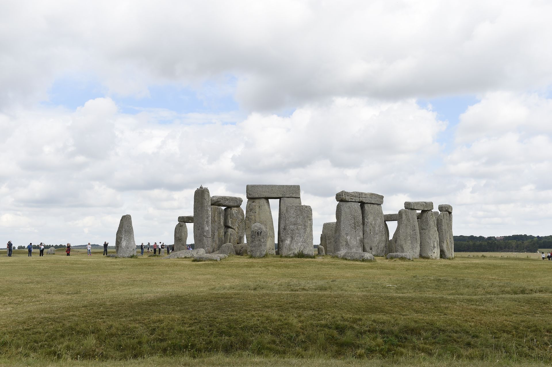 Stonehenge monument in a grassy field under a cloudy sky.