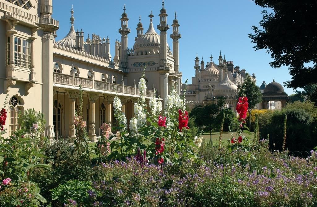 Brighton Royal Pavilion, ornate building with gardens and tall colorful flowers.