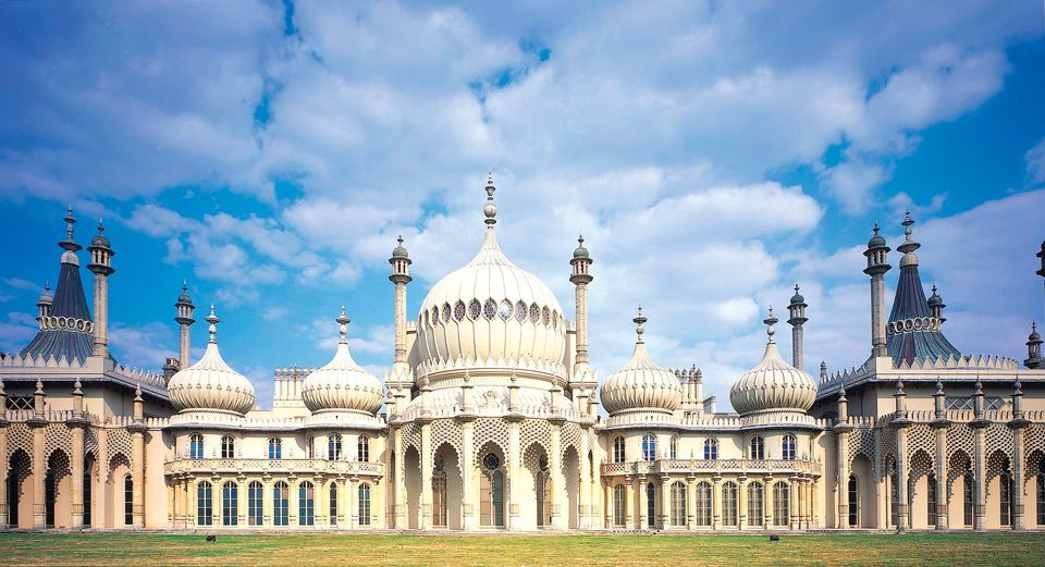 Brighton Pavilion, a cream-colored building with domes and minarets against a blue sky with clouds.