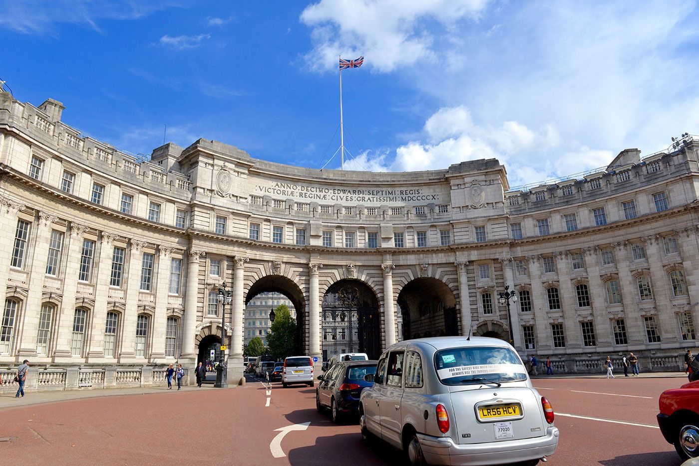 Admiralty Arch in London with traffic and a blue sky.