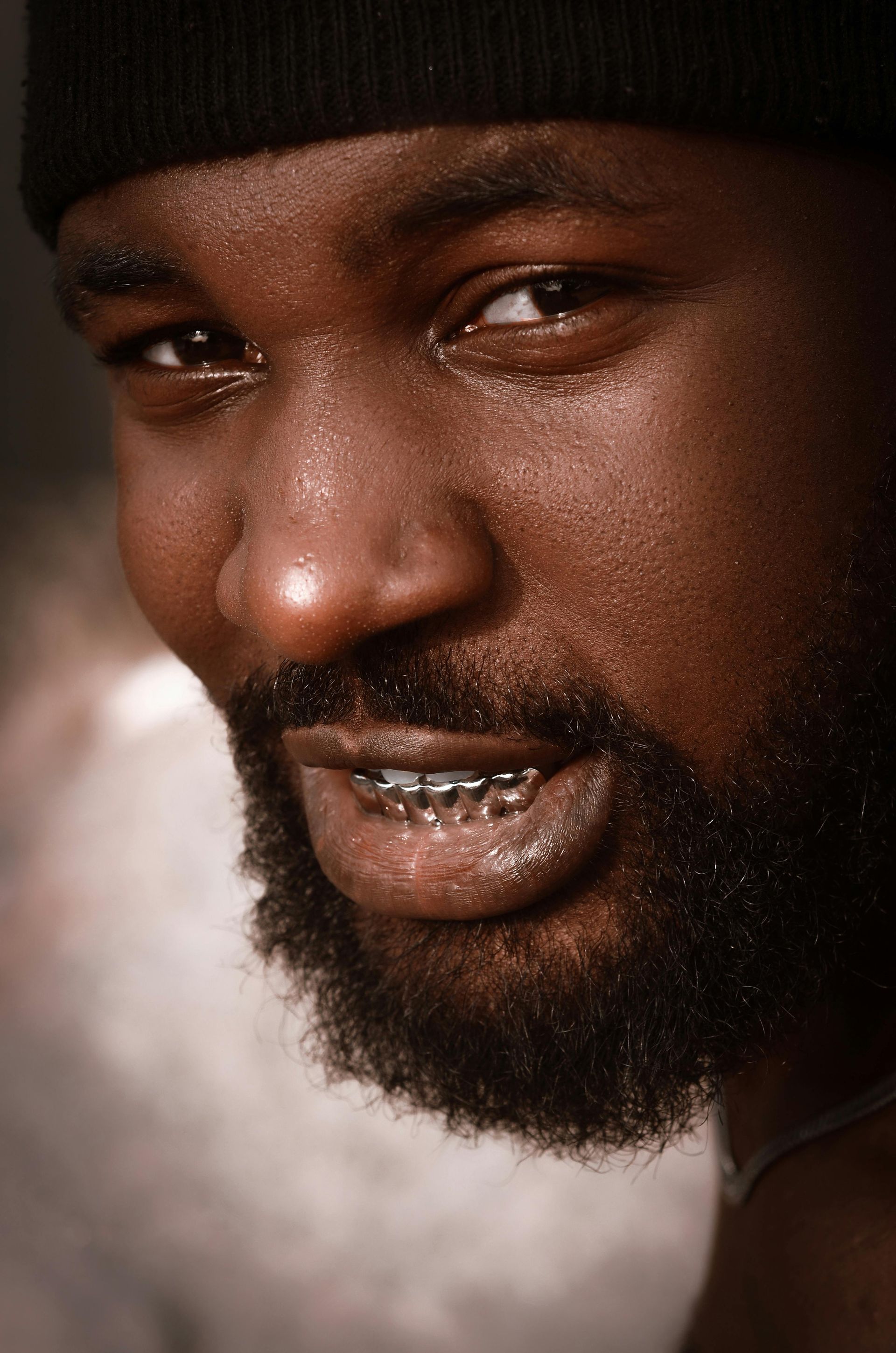A person is showing off his gold grillz