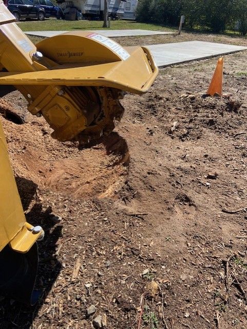 Yellow Machinery Grinding A Tree Stump