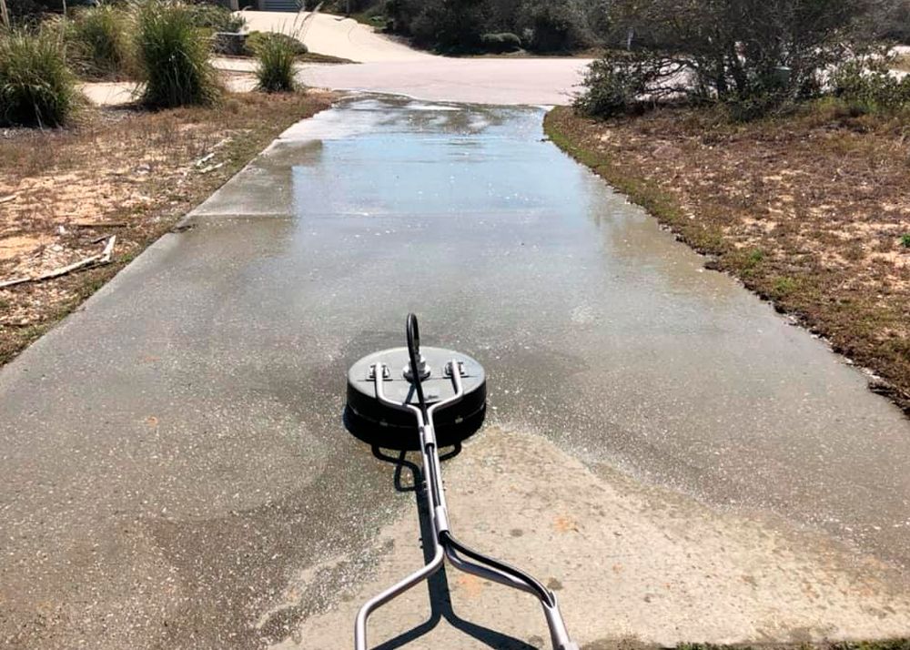 Pressure washer cleaning a wet concrete surface.