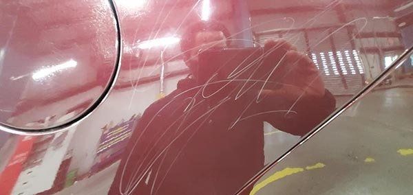 scratched red car before paint correction