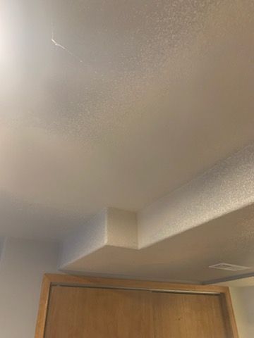 Ceiling corner above a wooden door in a beige room
