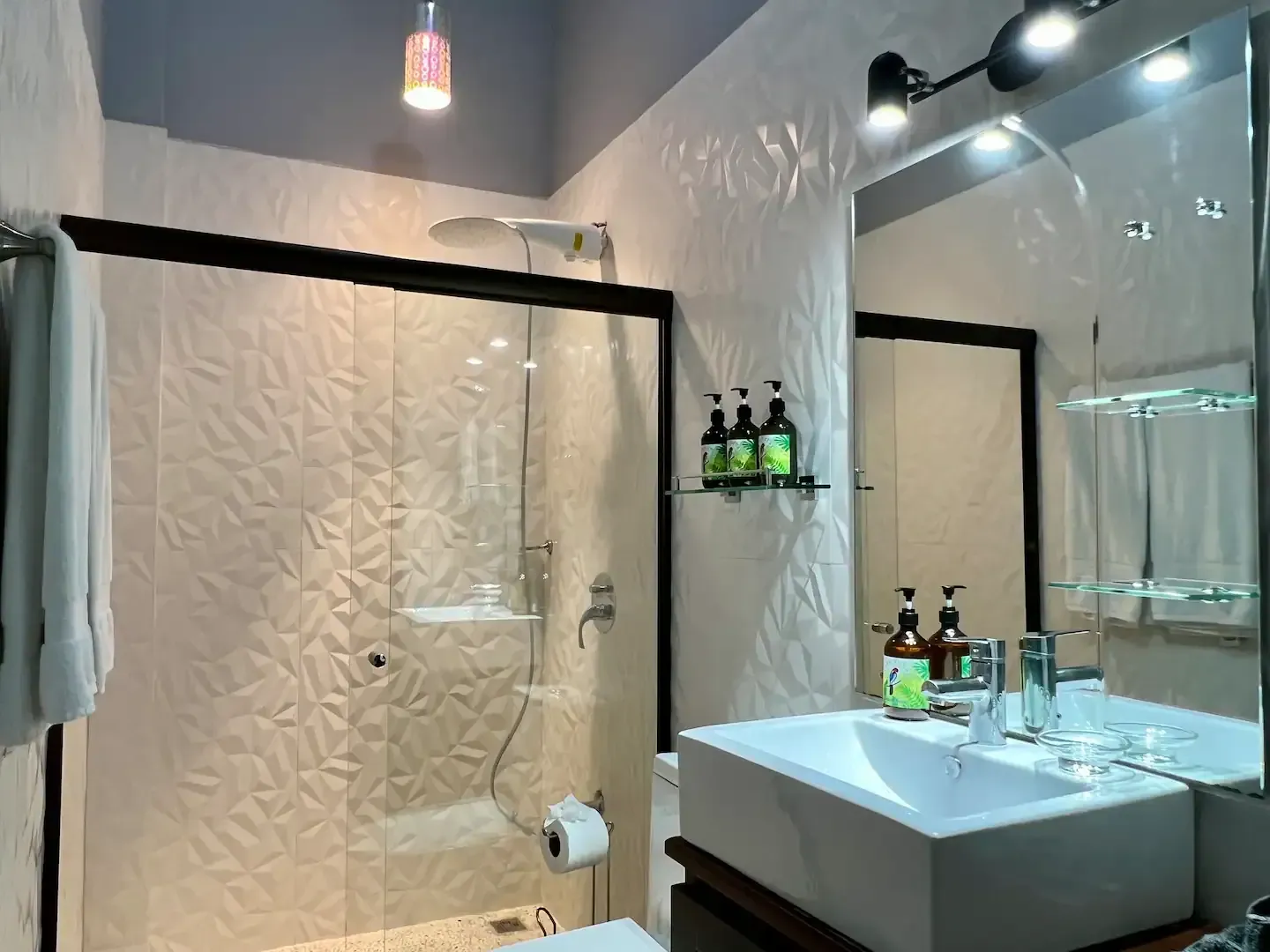 A bathroom with a sink , mirror and shower.
