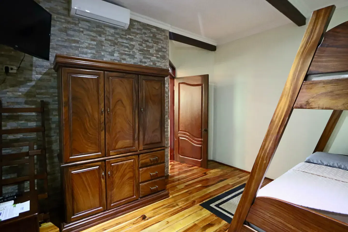 A bedroom with a bunk bed and a wardrobe
