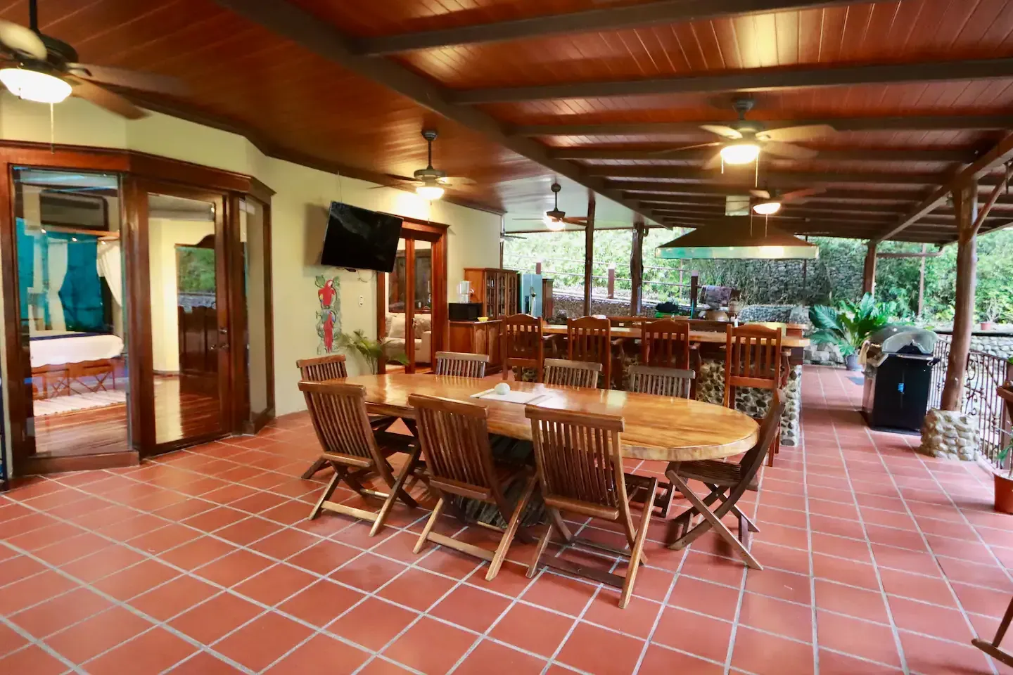 A large patio with a table and chairs and a ceiling fan.