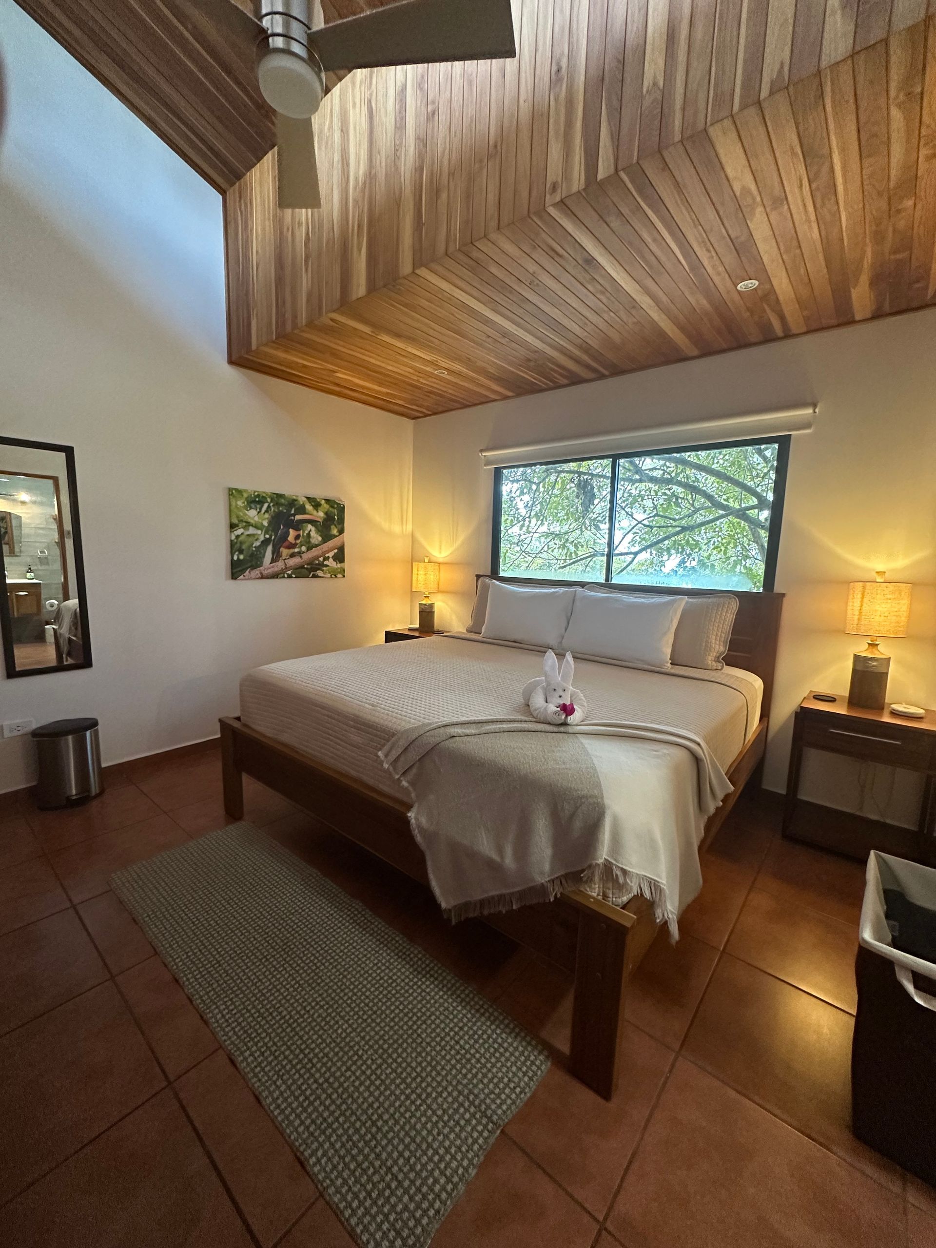 A bedroom with a large bed and a ceiling fan