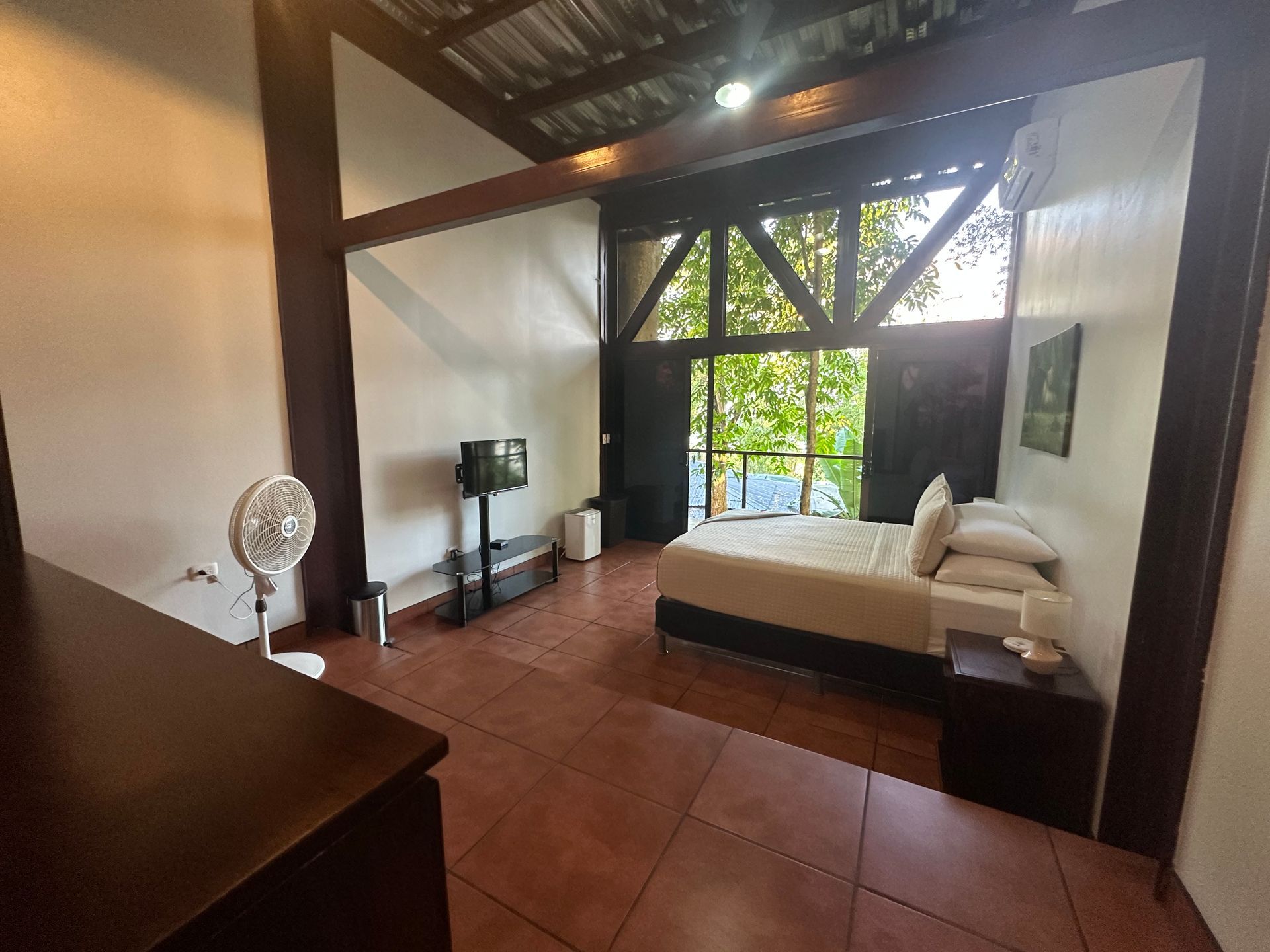 A bedroom with a large bed and a fan
