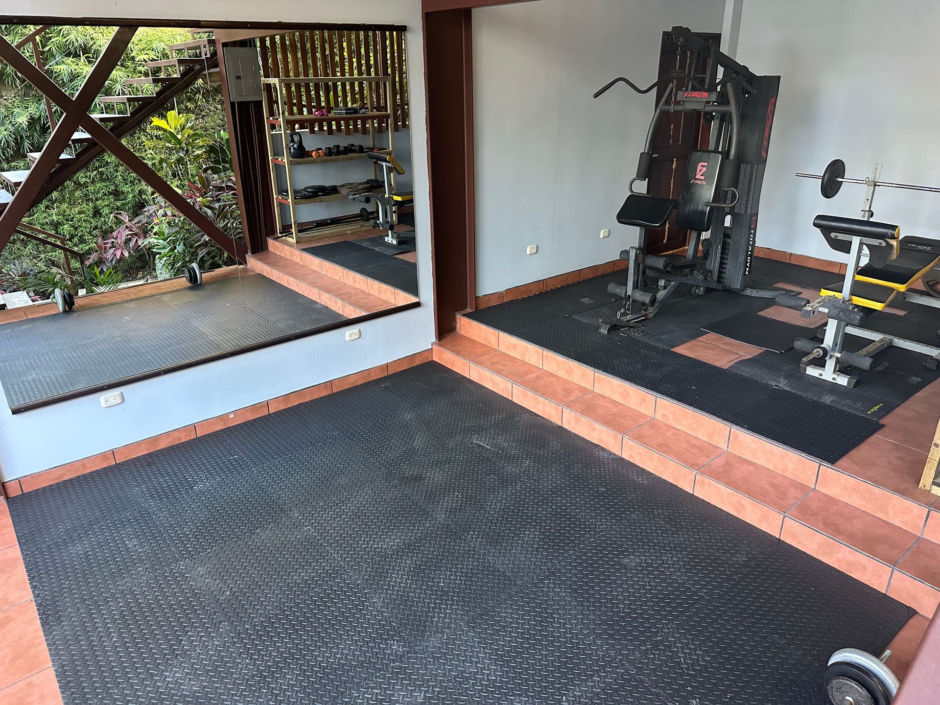 A gym with a lot of equipment and a large mirror