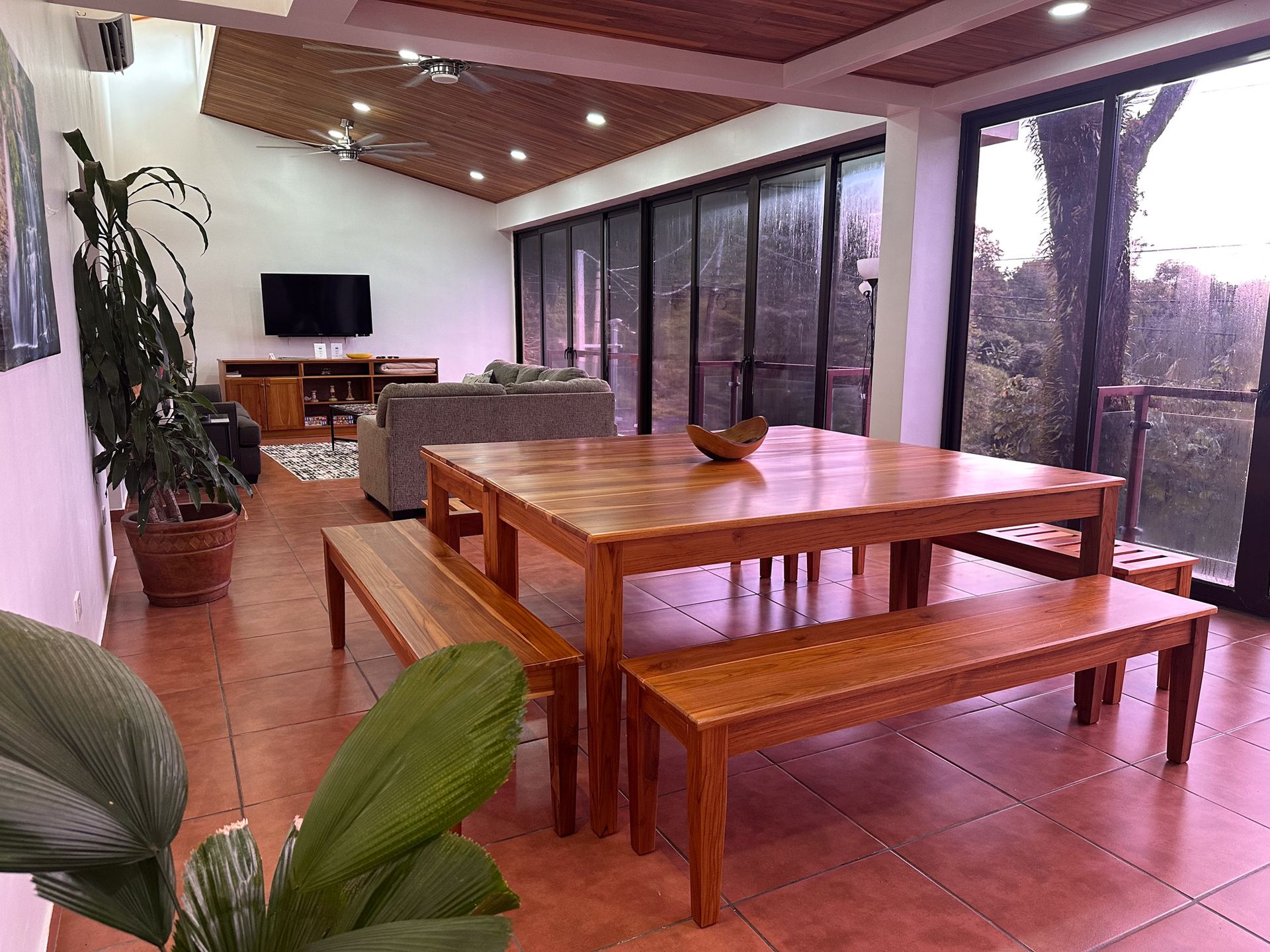 A large living room with a wooden table and benches.