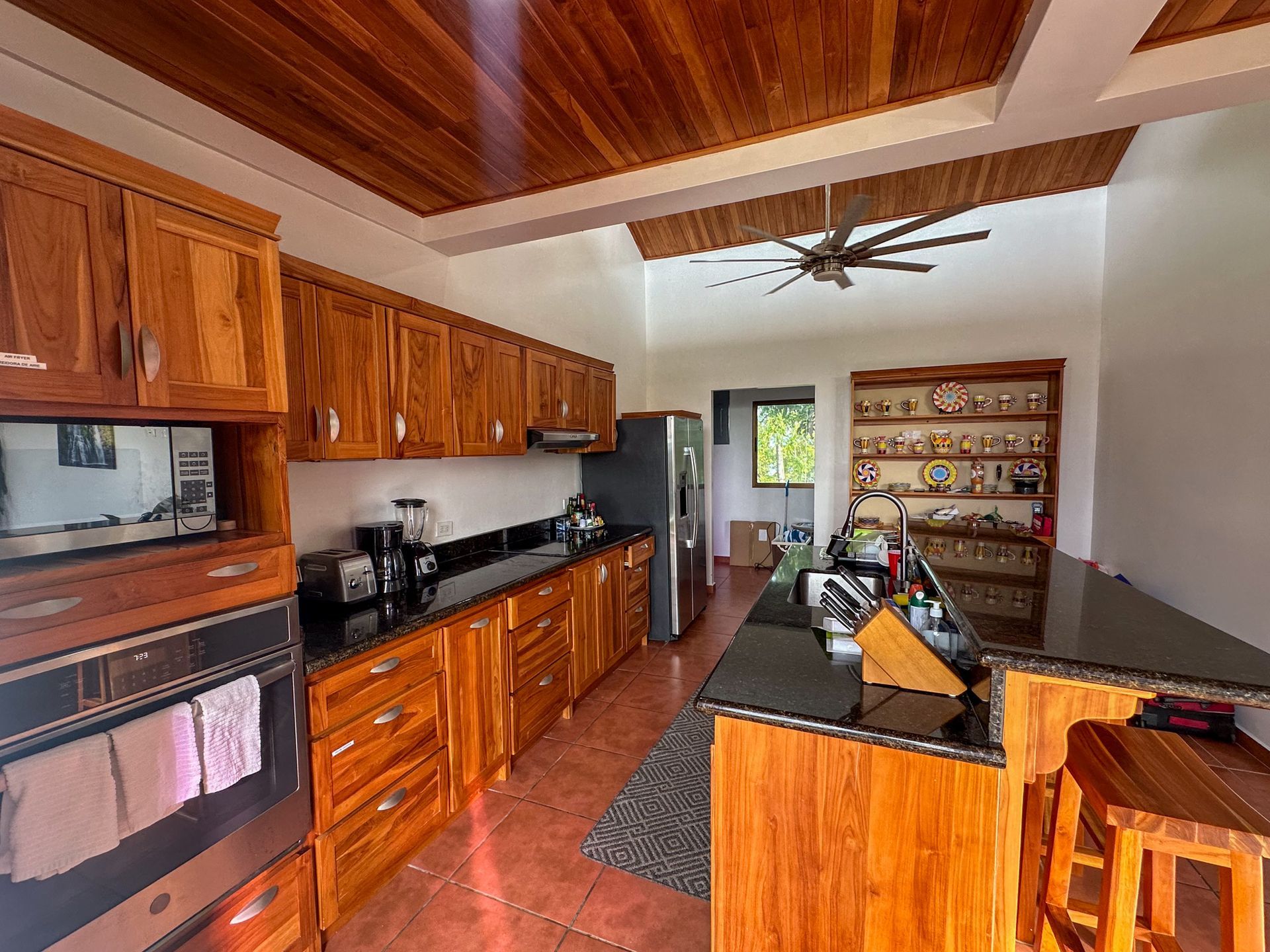 A kitchen with wooden cabinets and a ceiling fan.
