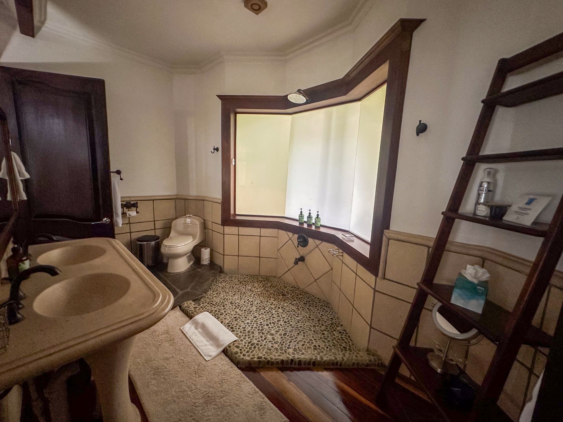 A bathroom with two sinks a toilet and a window