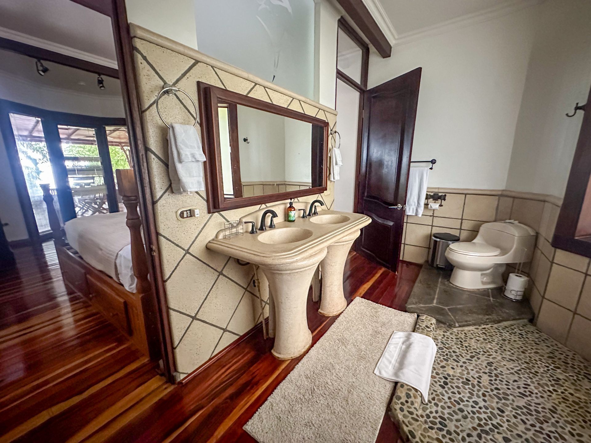 A bathroom with two sinks , a toilet and a mirror