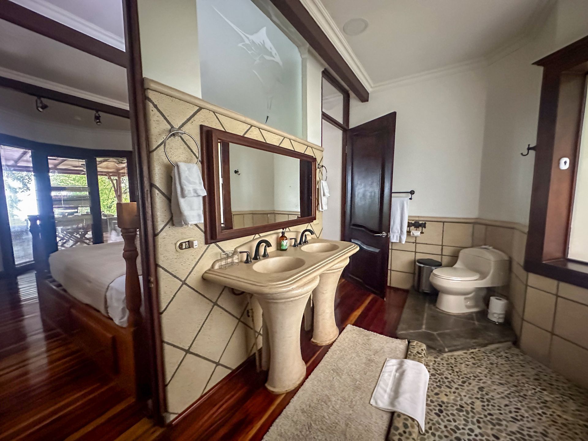 A bathroom with two sinks , a toilet and a mirror