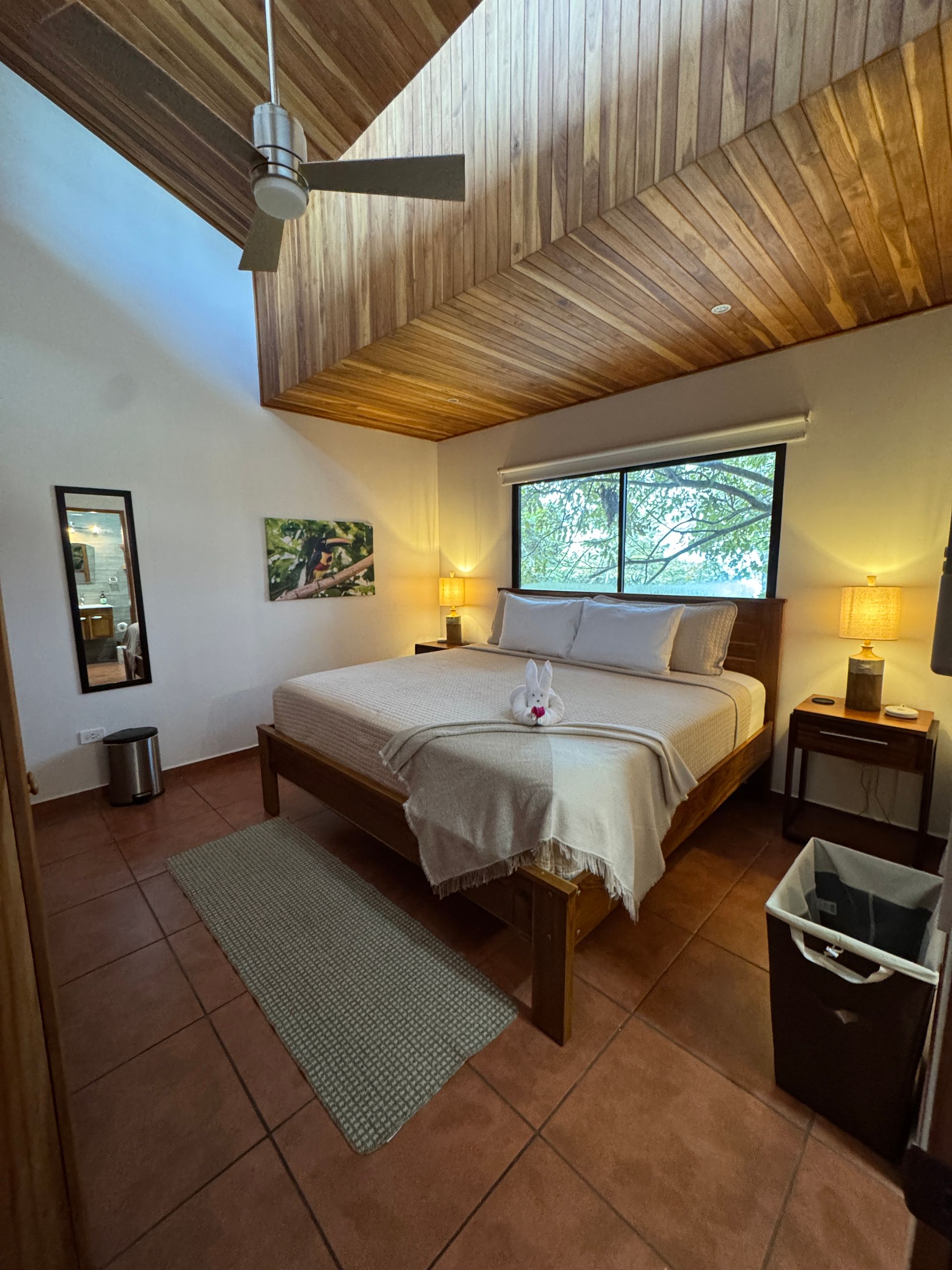 A bedroom with a king size bed and a ceiling fan.