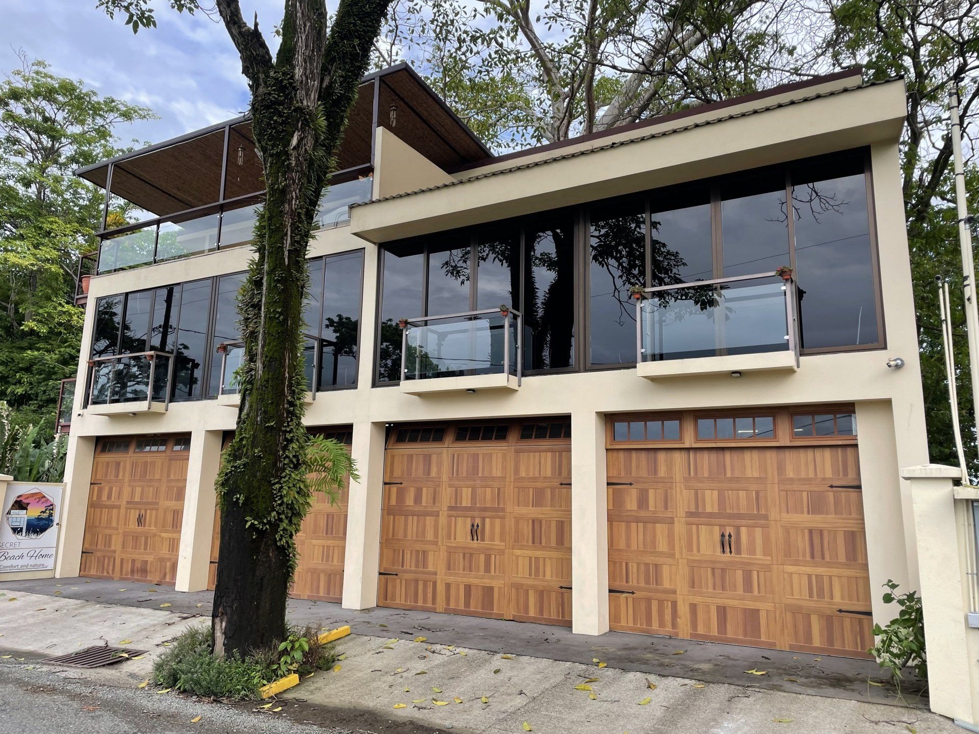 A large house with a lot of windows and wooden garage doors