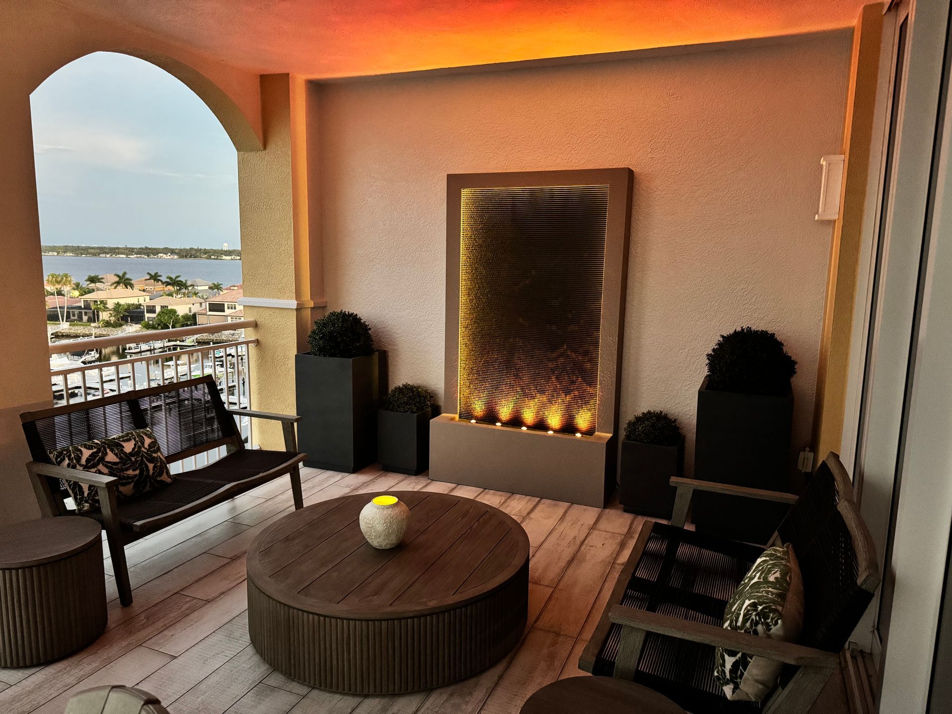 Balcony with water feature and seating, overlooking a waterfront