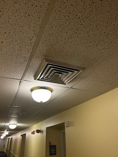 A hallway with a ceiling fan and a light on the ceiling.