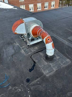 There is a fan on the roof of a building.