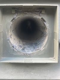 A close up of a dirty air vent on a house.
