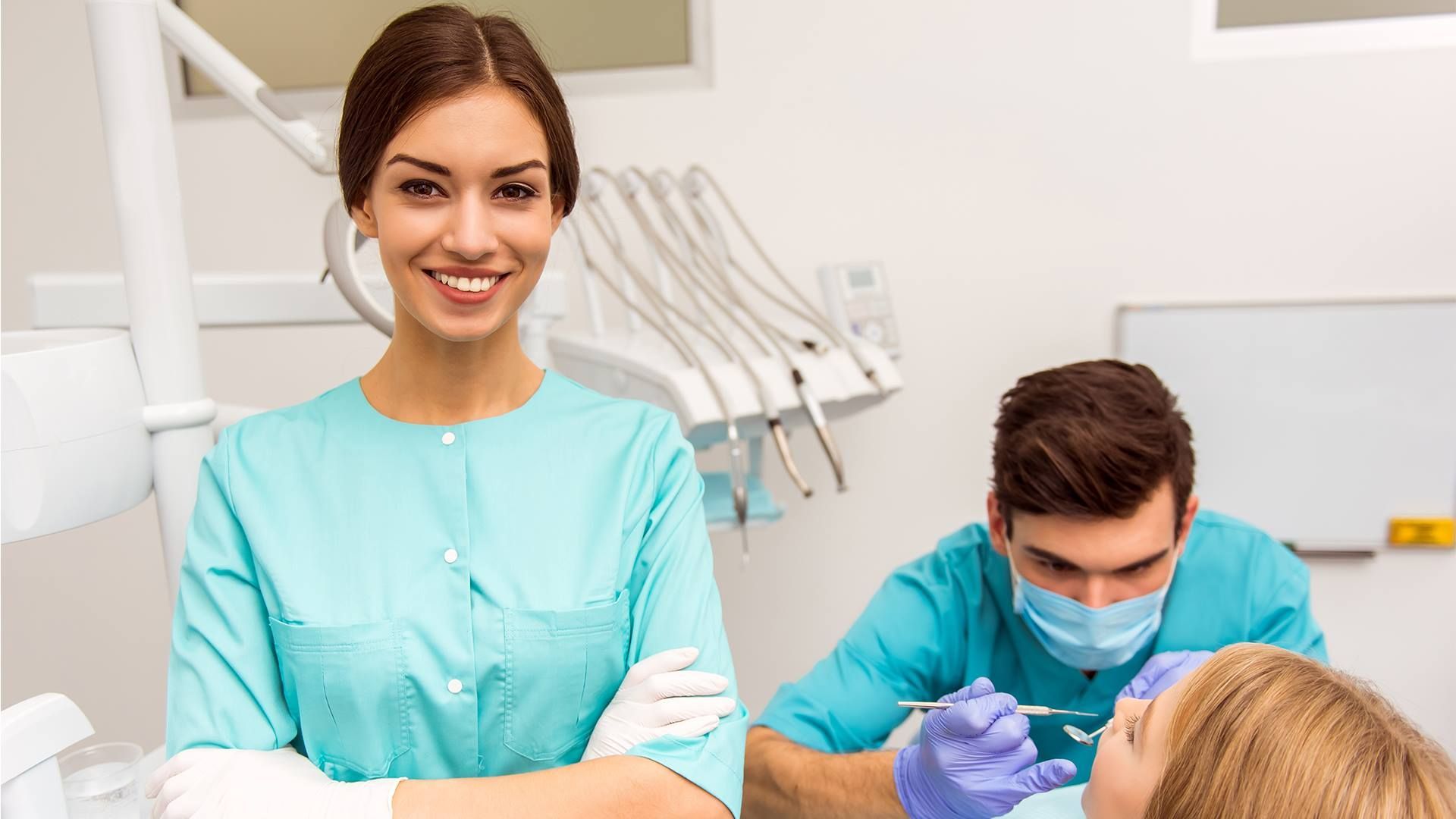 A Female Dentist Is Standing in Front of A Patient in A Dental Office — Steve King Dental Group in Manunda, QLD