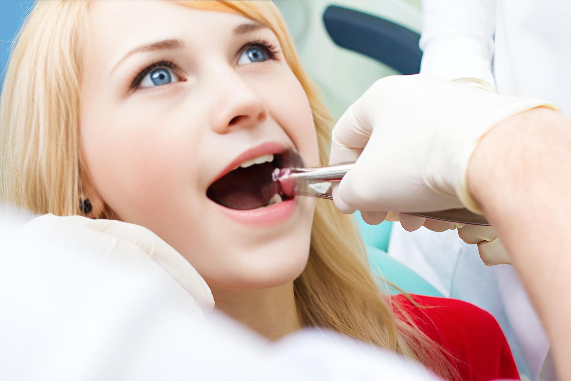 A Woman Is Getting Her Teeth Examined by A Dentist — Steve King Dental Group in Manunda, QLD