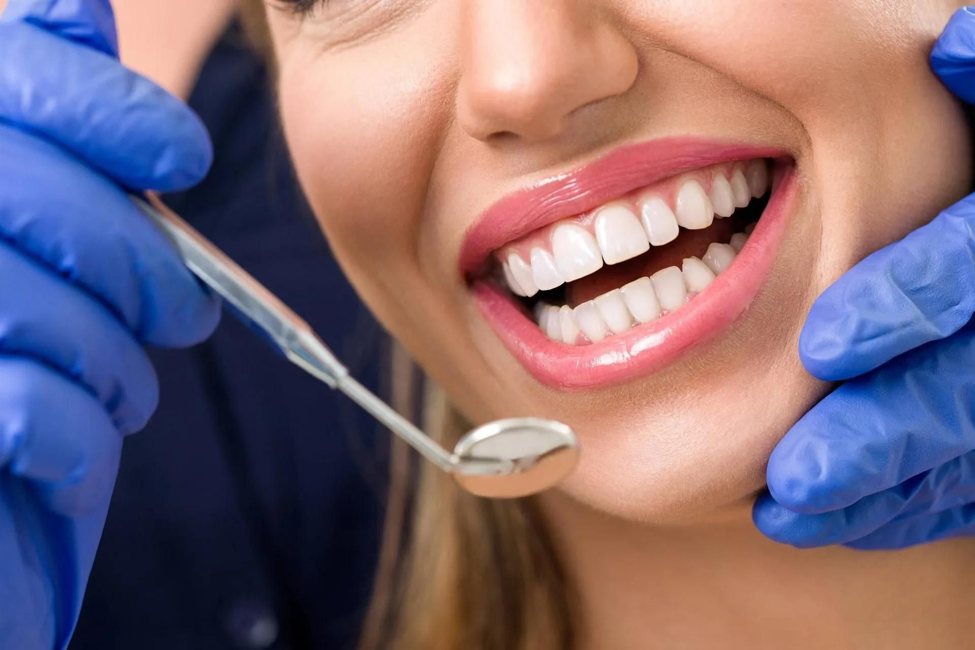 A Woman Is Getting Her Teeth Examined by A Dentist — Steve King Dental Group in Manunda, QLD
