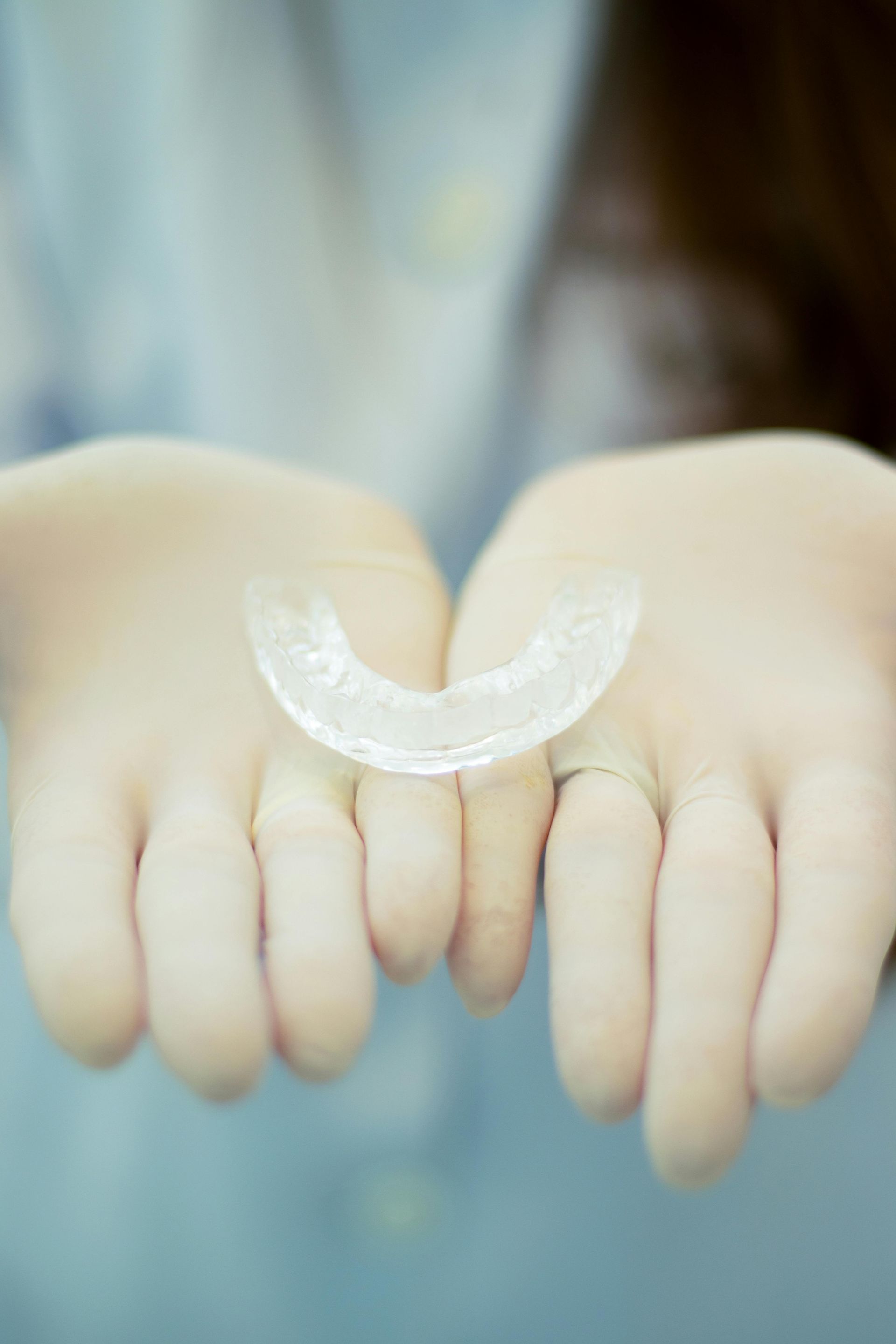 A Person Is Holding A Clear Mouth Guard In Their Hands — Steve King Dental Group in Manunda, QLD