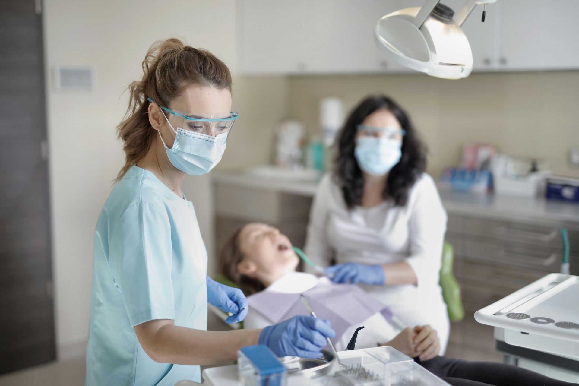 A Dentist Is Examining A Patient 's Teeth In A Dental Office — Steve King Dental Group in Manunda, QLD