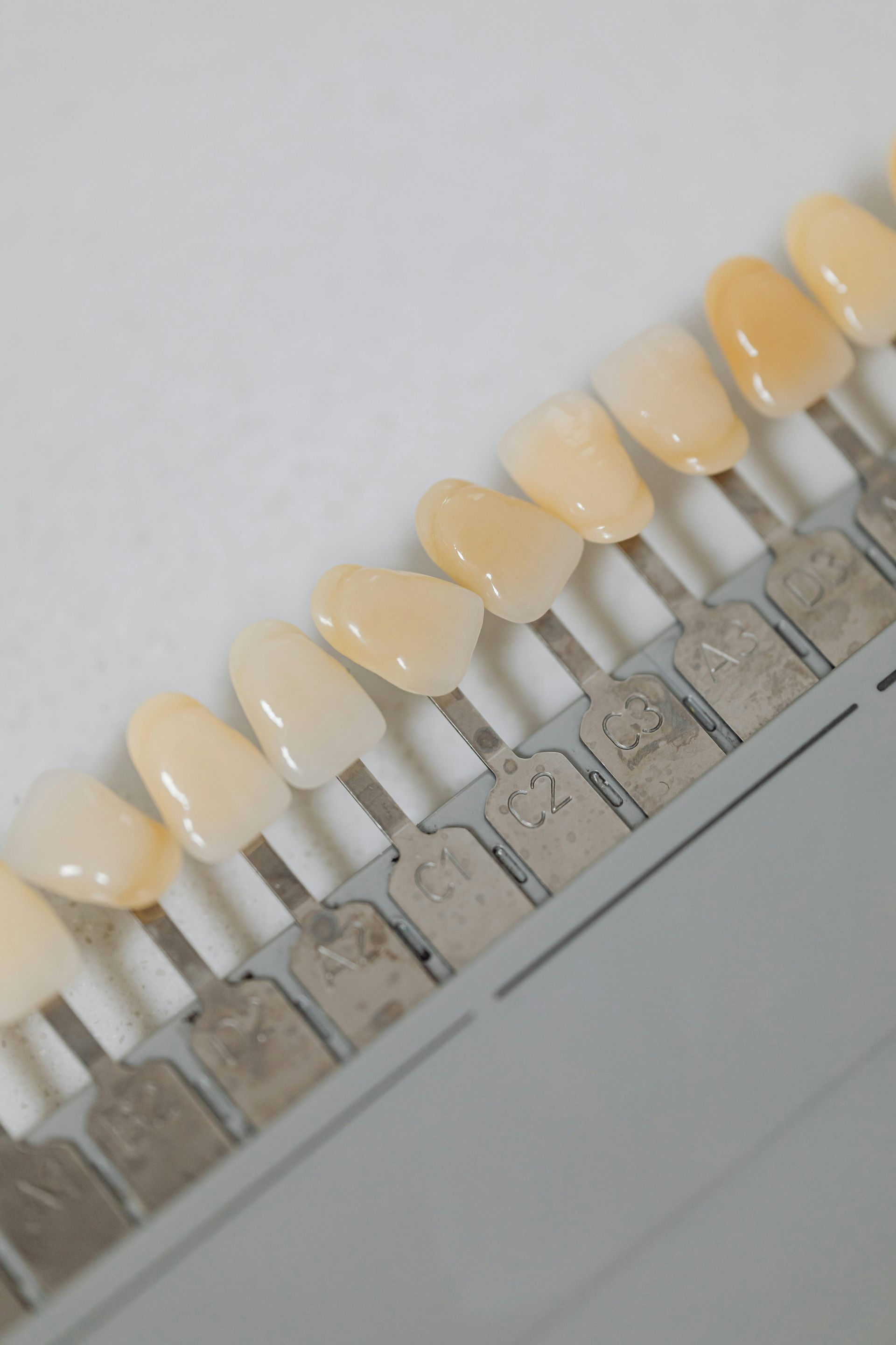 A Row Of Tooth Shades On A White Surface — Steve King Dental Group in Manunda, QLD