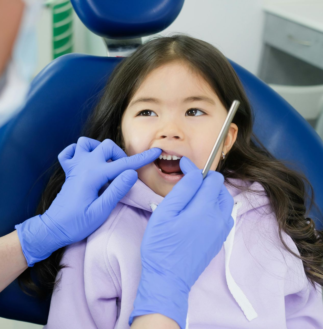 A Woman Is Examining a Man 's Teeth in A Dental Office — Steve King Dental Group in Manunda, QLD