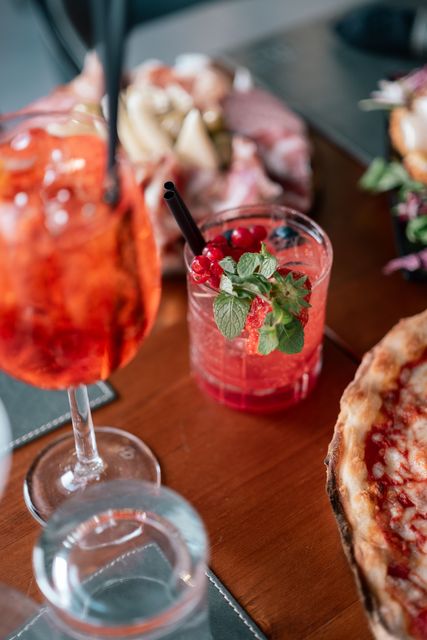 Bicchieri da cocktail e una fetta di pizza su un tavolo di ristorante.