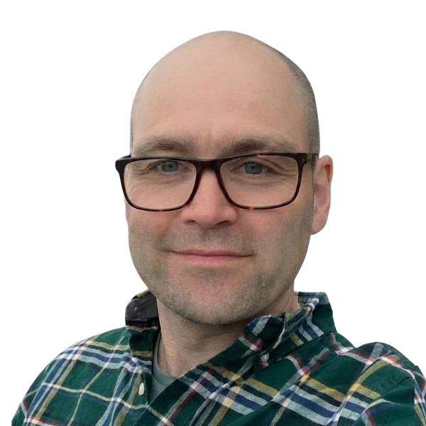 Man wearing glasses and a green plaid shirt, smiling against a white background