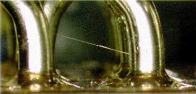 Close-up of shiny metal rings on a dark surface with a greenish reflection