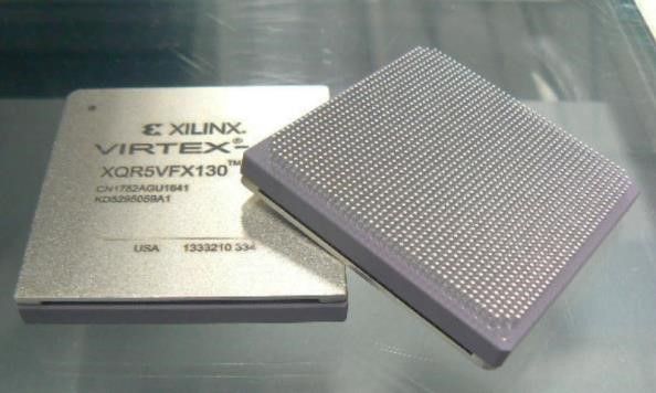 Two Xilinx Virtex FPGAs, one showing the chip label and one flipped to reveal the pin grid underside