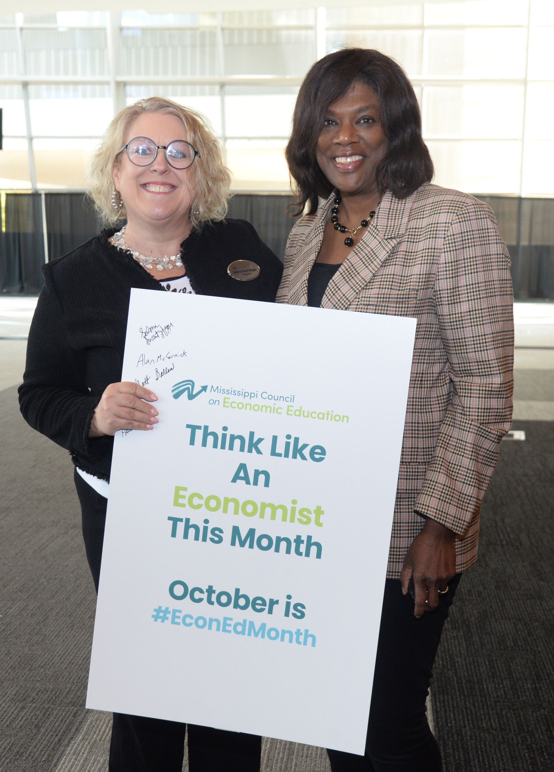 Two women holding sign that reads 