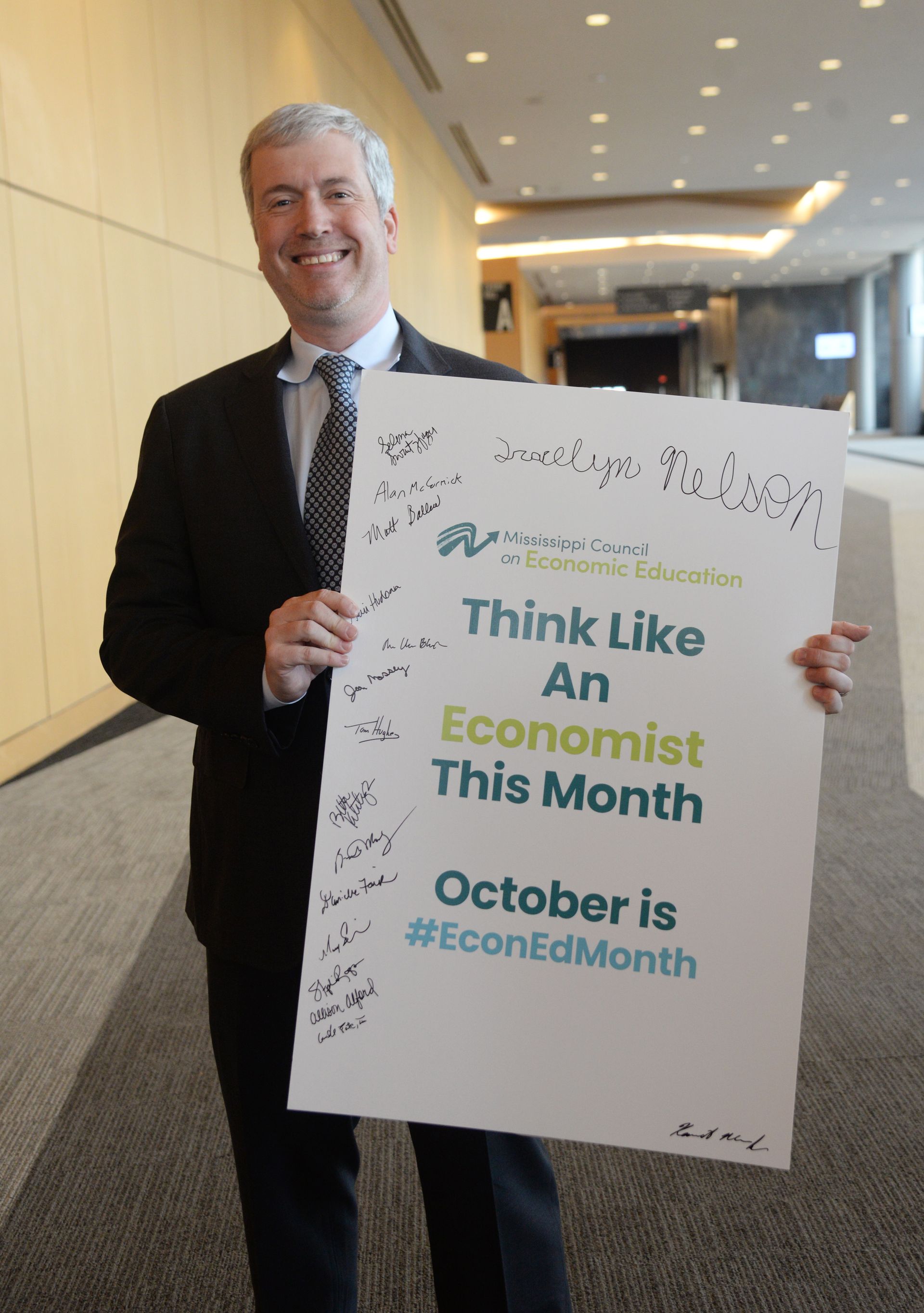 Man in suit holds sign: 