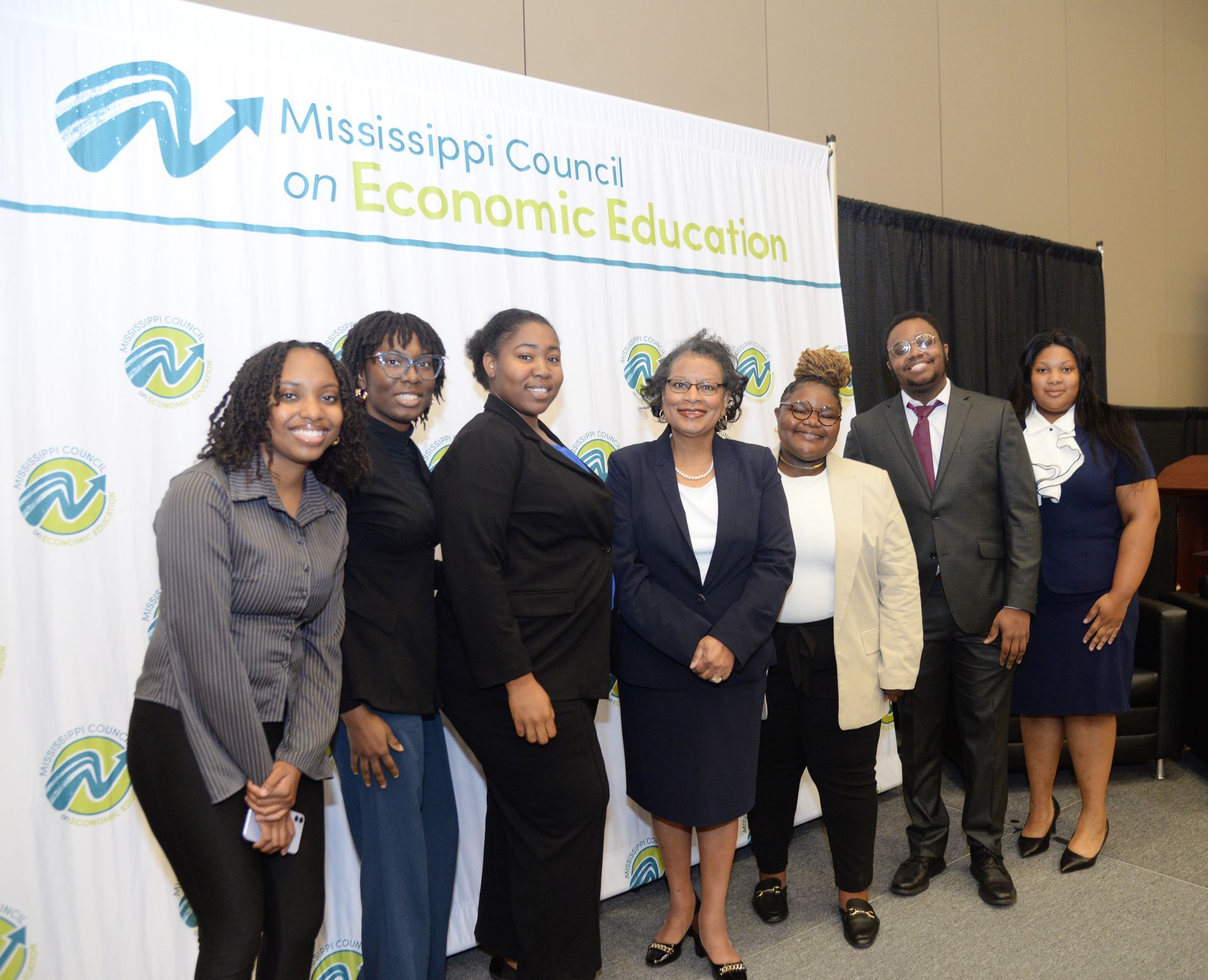 Group of people posing in front of a backdrop for the Mississippi Council on Economic Education.