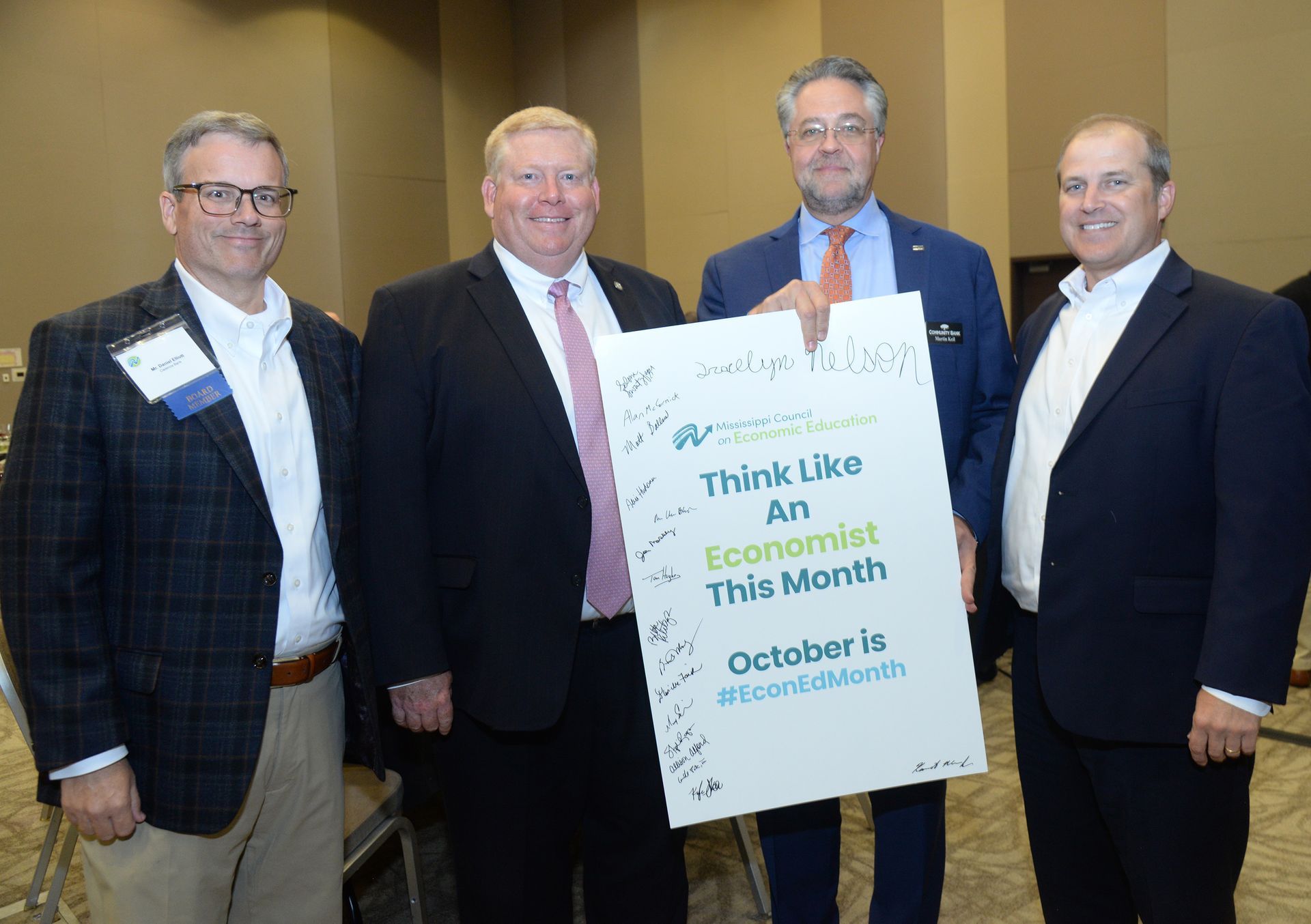 Four men hold a sign that says 