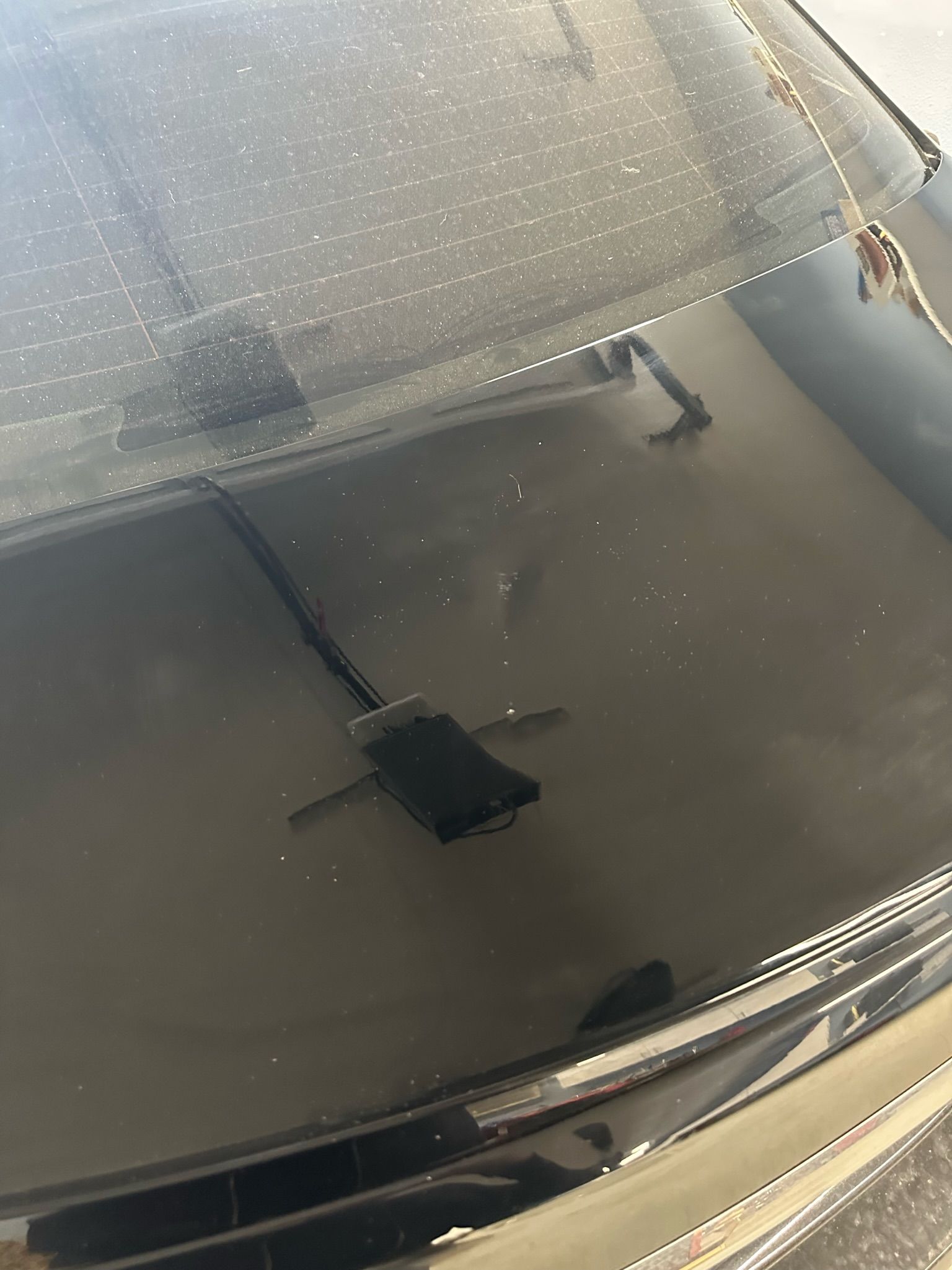 A close up of the hood of a car with a broken windshield.