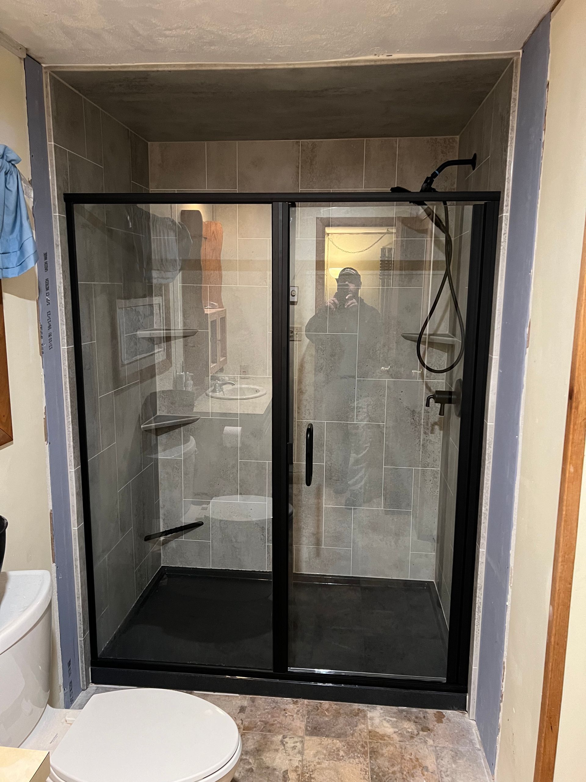 A bathroom with a walk in shower and a toilet.