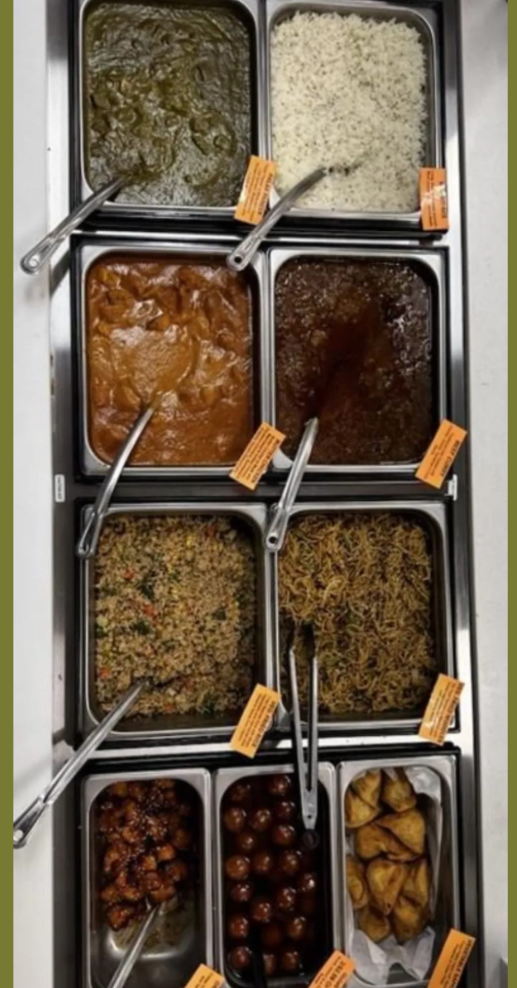 Food buffet with various dishes in metal containers.