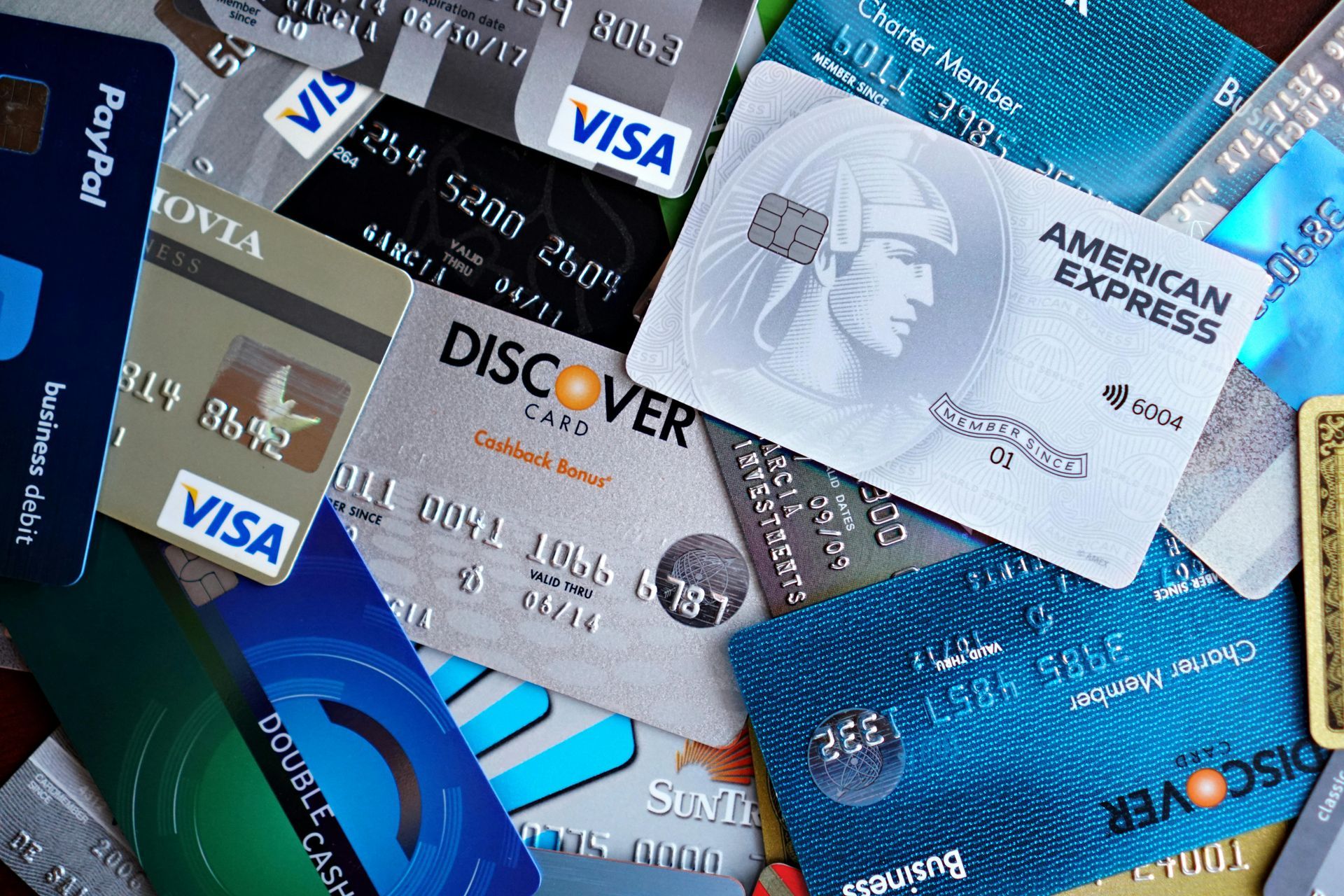 A cluttered pile of various credit and debit cards from different financial institutions and networks.
