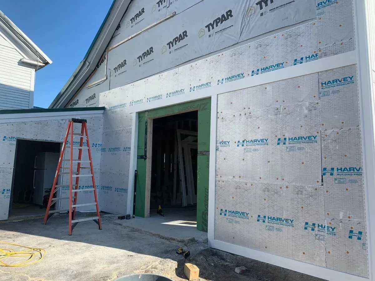A ladder is sitting in front of a building under construction.