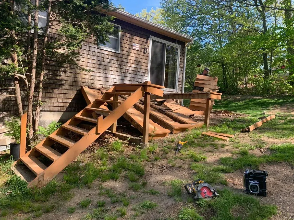 A wooden deck is being built in front of a house.